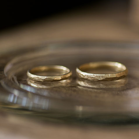 ガラスのお皿に並べたK18イエローゴールドの結婚指輪のペアショット。